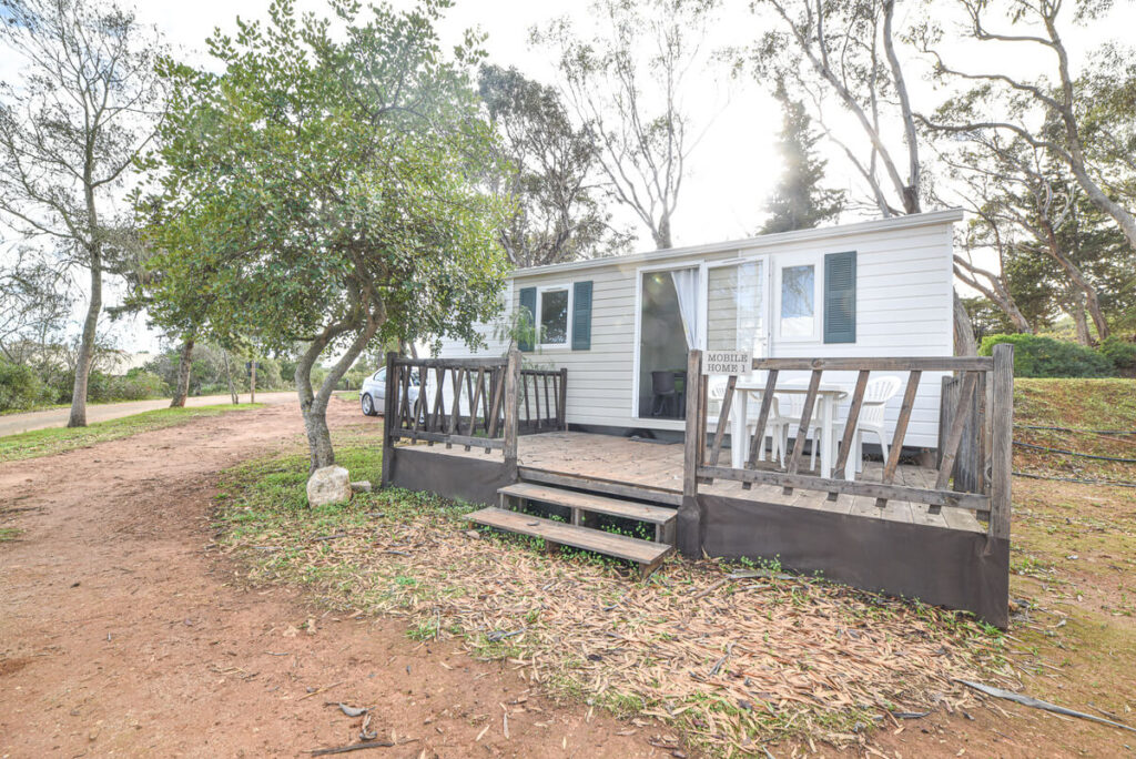 Espaço exterior mobile home, com mesa e cadeiras num deck