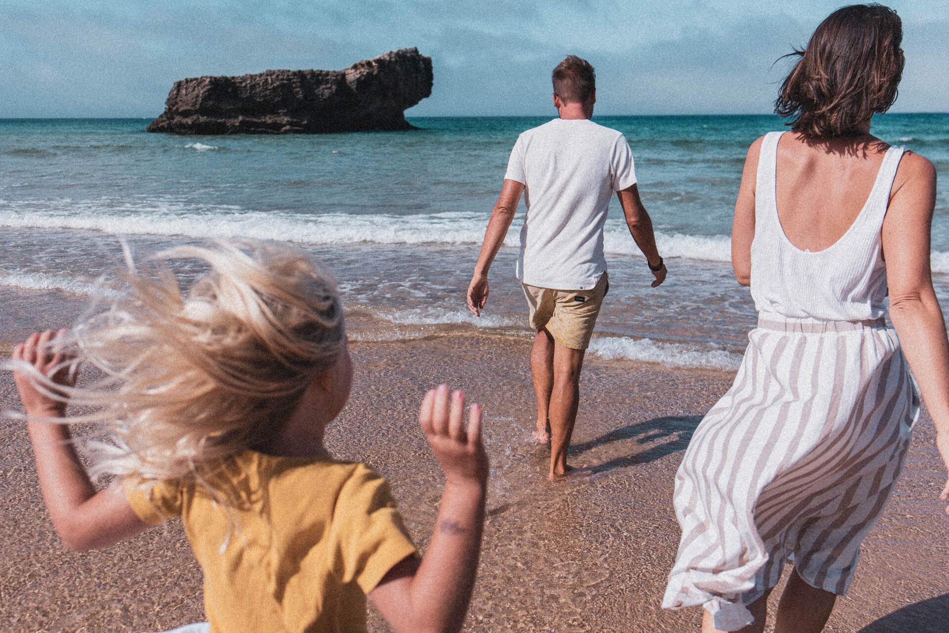 Família a fazer passeio pela praia