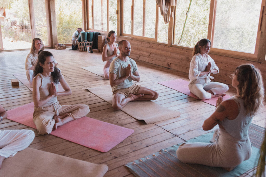 Pessoas reunidas em uma sala meditando