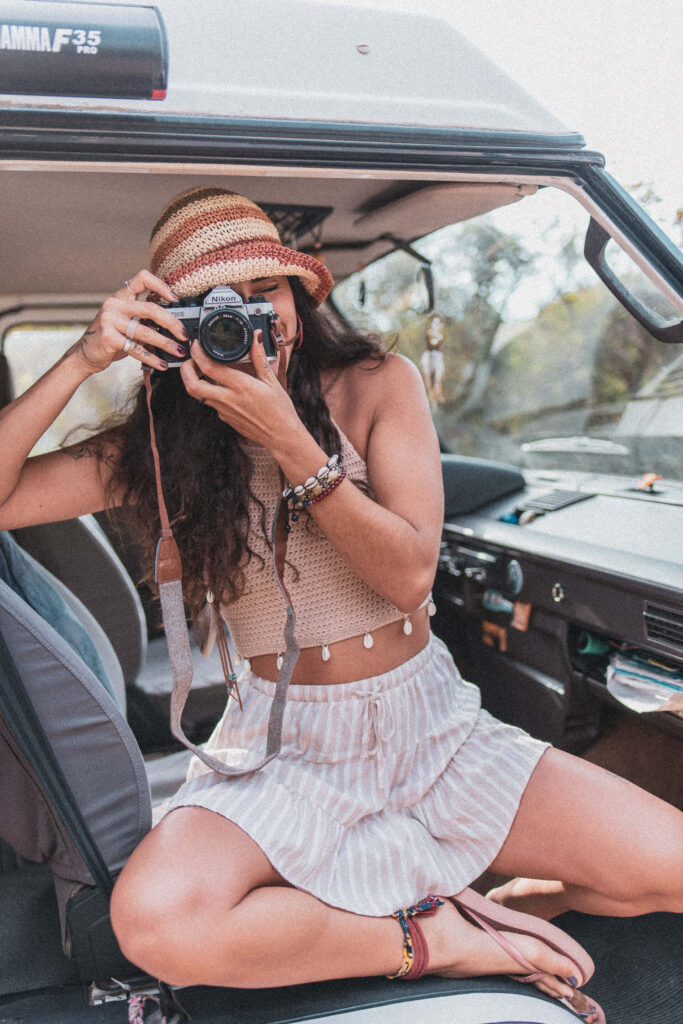 Mulher dentro de uma carrinha a apontar a câmara para tirar uma foto."