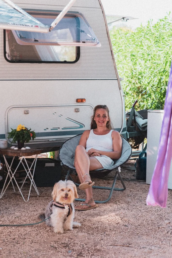 Mulher sentada sorrindo com o seu cachorro