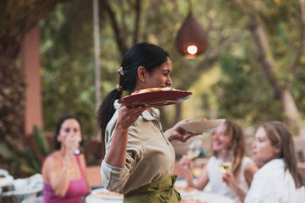 Empregada de mesa a carregar um prato de comida