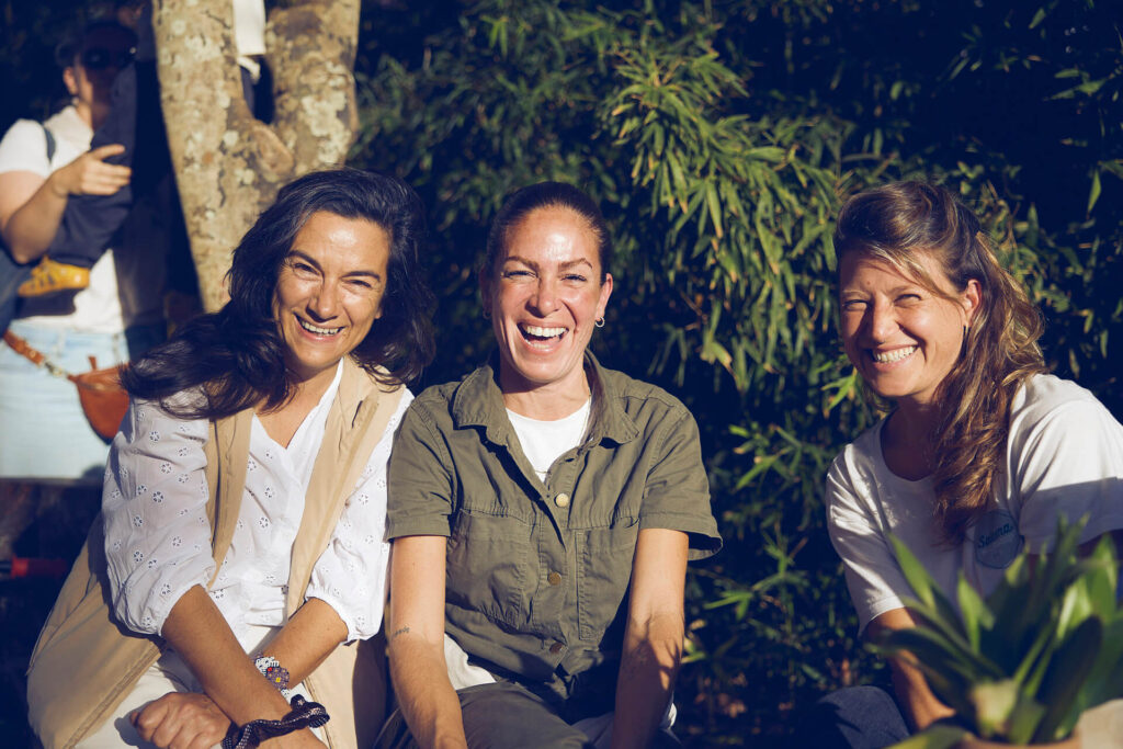 Mulheres sentadas a sorrir.